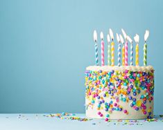 a birthday cake with many candles and sprinkles