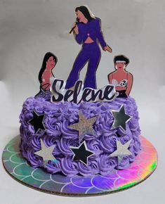 a cake with purple frosting and stars on top that says selene, surrounded by cutouts of people