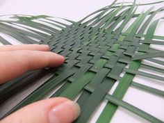 a person is cutting grass with scissors on a white tablecloth that's laid out to look like palm leaves