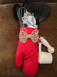 an oven mitt with utensils and cooking utensils in it sitting on a couch