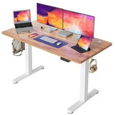 a computer desk with two monitors and a laptop on it, sitting next to each other