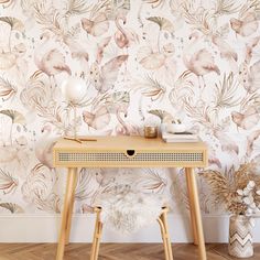 a wooden table sitting in front of a wallpapered with pink flamingos and leaves