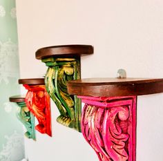 three wooden shelfs with painted designs on them