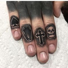 two fingers with different tattoos on them and one has a skull, an arrow, and a diamond