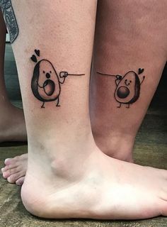 two people with matching tattoos on their legs, one has a dog and the other has a heart