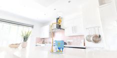 a kitchen with a white counter top next to a potted plant on the counter