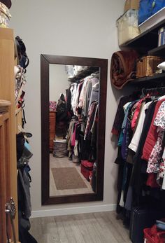 the closet is full of clothes and other items, including an open door that leads to a walk - in closet