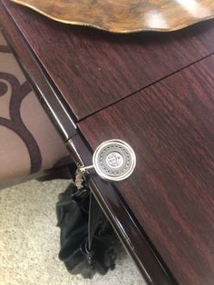 a close up of a drawer on a wooden table with a black bag underneath it