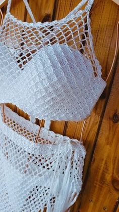 two white bras hanging on a wooden wall