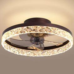 a ceiling fan that is lit up and has lights on top of it, with a circular