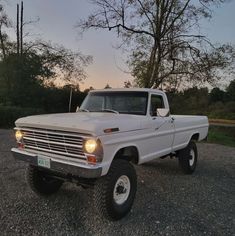 a white truck parked on top of a gravel road