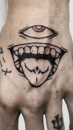 a person's hand with tattoos on it and an evil face in the middle