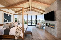 a bedroom with a fireplace and television mounted on the wall next to it's bed