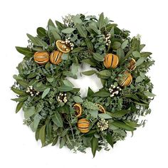 a wreath with oranges and greenery on it