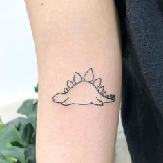 a small tattoo on the arm of a person with a dinosaur in it's head