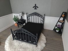 a black bed sitting on top of a wooden floor