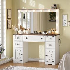 a white vanity with lights on it in a bedroom