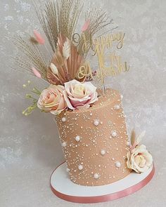 a birthday cake decorated with flowers and feathers