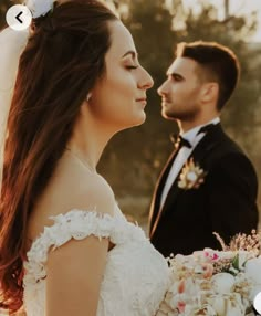 the bride and groom are standing close together