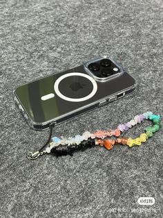 an iphone case sitting on top of a table next to a beaded lanyard