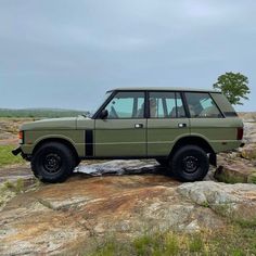 an suv parked on top of a large rock