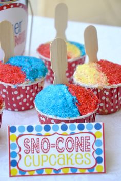 colorful cupcakes with popsicle toppers on a table