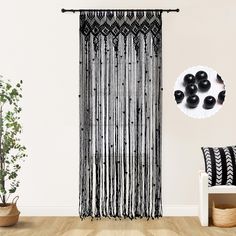 black and white curtains hanging from the side of a wall next to a plant in a living room