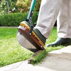 a person using a lawn mower to cut grass