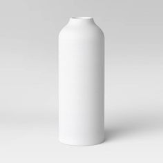 a white vase sitting on top of a table