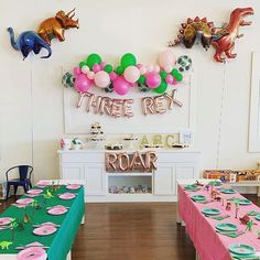 there are many tables with pink and green tablecloths on them in the room