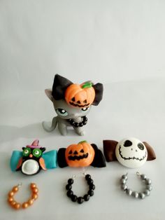 there are many different halloween items on the white tablecloth, including bracelets and rings