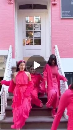 two women in pink dresses are dancing on the steps