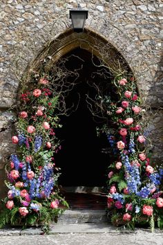 an instagram page with flowers and vines on the front door to a stone building