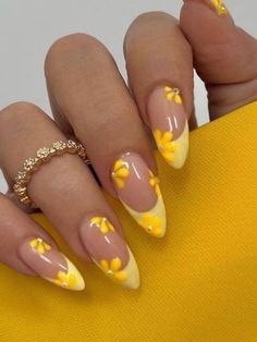 a woman's nails with yellow flowers on them