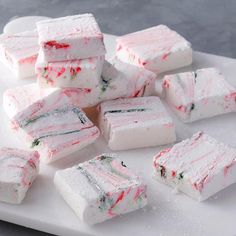 several pieces of cake sitting on top of a white cutting board next to each other