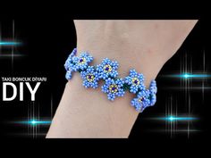 the bracelet is decorated with beads and flowers on it's wrist, which reads diy