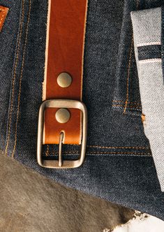 a leather belt on the back of a pair of jeans