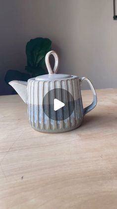 a ceramic teapot sitting on top of a wooden table