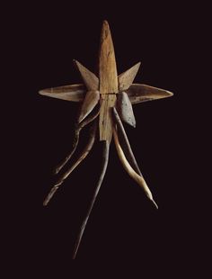 an old wooden star with long horns hanging from it's side on a black background