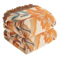 two throw pillows stacked on top of each other, one with an orange and blue floral design