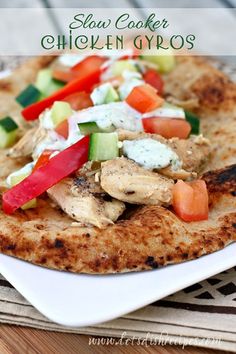 chicken gyros with tomatoes, cucumbers and peppers on a white plate