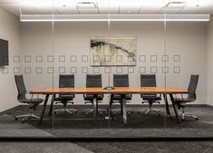 an empty conference room with black chairs and a wooden table