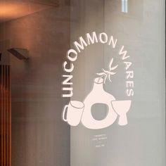 a window with the words uncommon wares on it and an image of a vase