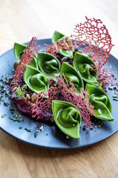 a blue plate topped with green and red food