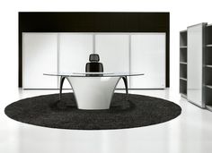 an office with a round glass table and black rug