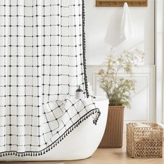 a bathroom with a bathtub, shower curtain and basket on the floor next to it