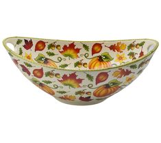 a white bowl with fall leaves and acorns on the rim, sitting on a white background