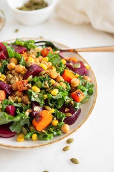 a salad with beets, carrots and chickpeas is on a plate