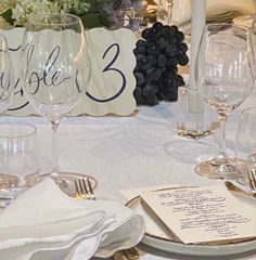 the table is set with wine glasses, silverware and place settings for an event