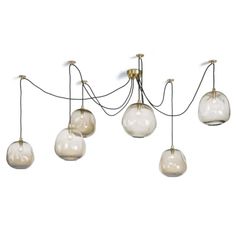 five glass globes hanging from the ceiling with cords attached to them, and one light bulb on each end